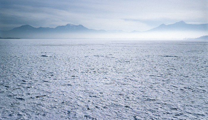 Zugefrorener Chiemsee und Chiemgauer Alpen