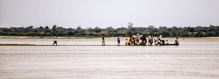 Menschen beim Warten auf die Flussfähre Rufiji