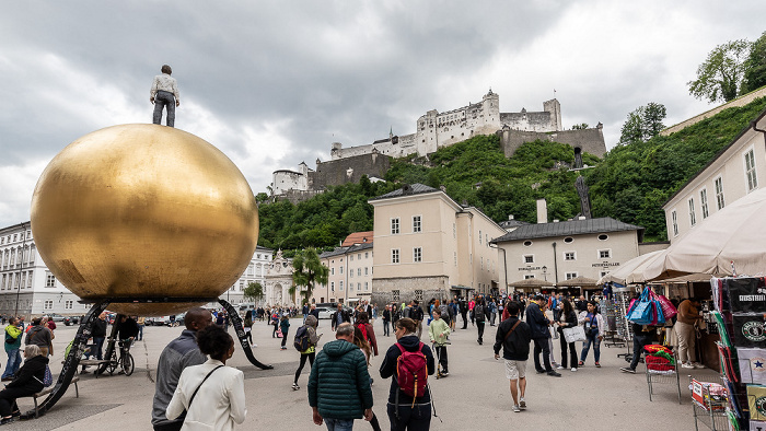 Salzburg Altstadt: Kapitelplatz mit dem Kunstwerk Sphaera (Kugel mit männlicher Figur) Festung Hohensalzburg